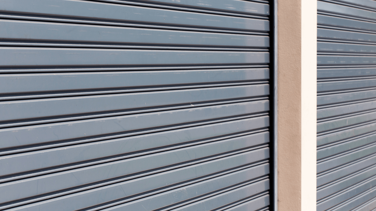 Close-up view of a metal roller shutter door with horizontal slats, showcasing its sleek design and functionality.